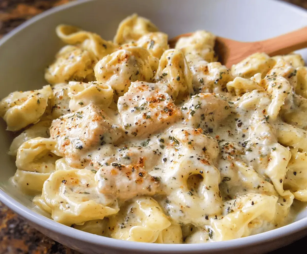 Creamy Garlic Parmesan Chicken Tortellini served with fresh herbs on a white plate