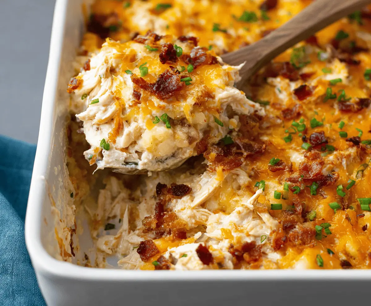Delicious Crack Chicken Casserole with crispy bacon, melted cheese, and creamy ranch dressing served in a baking dish