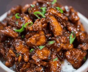 Delicious Crock Pot Bourbon Chicken served over rice with a glossy sauce and garnished with green onions, perfect for a flavorful and easy dinner recipe.