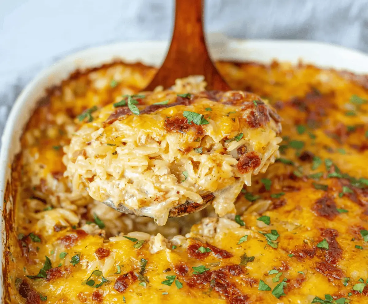 Delicious French Onion Chicken Orzo Casserole topped with melted cheese and caramelized onions in a baking dish