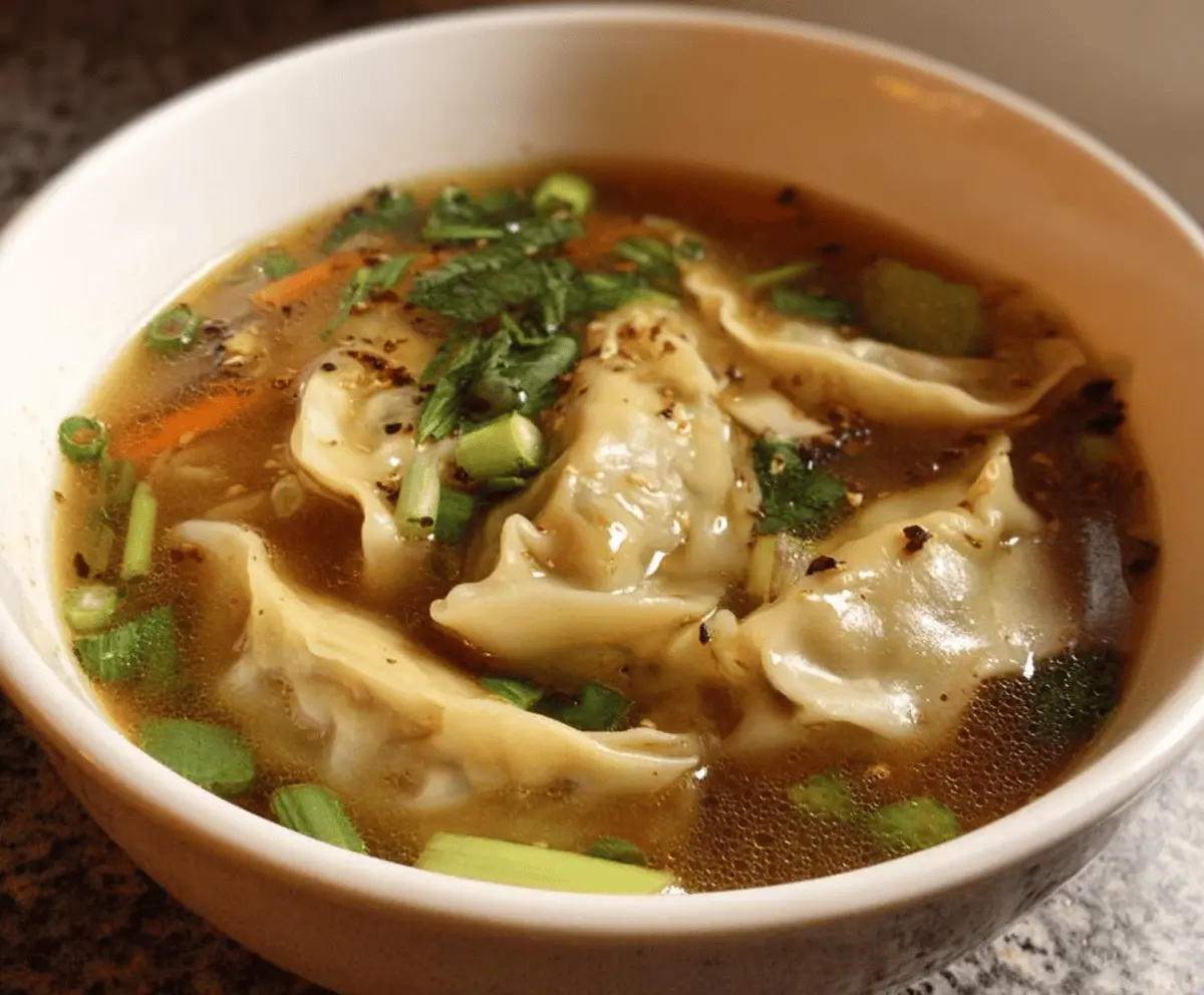Bowl of easy potsticker soup with vegetables and green onions, perfect for comfort food lovers.