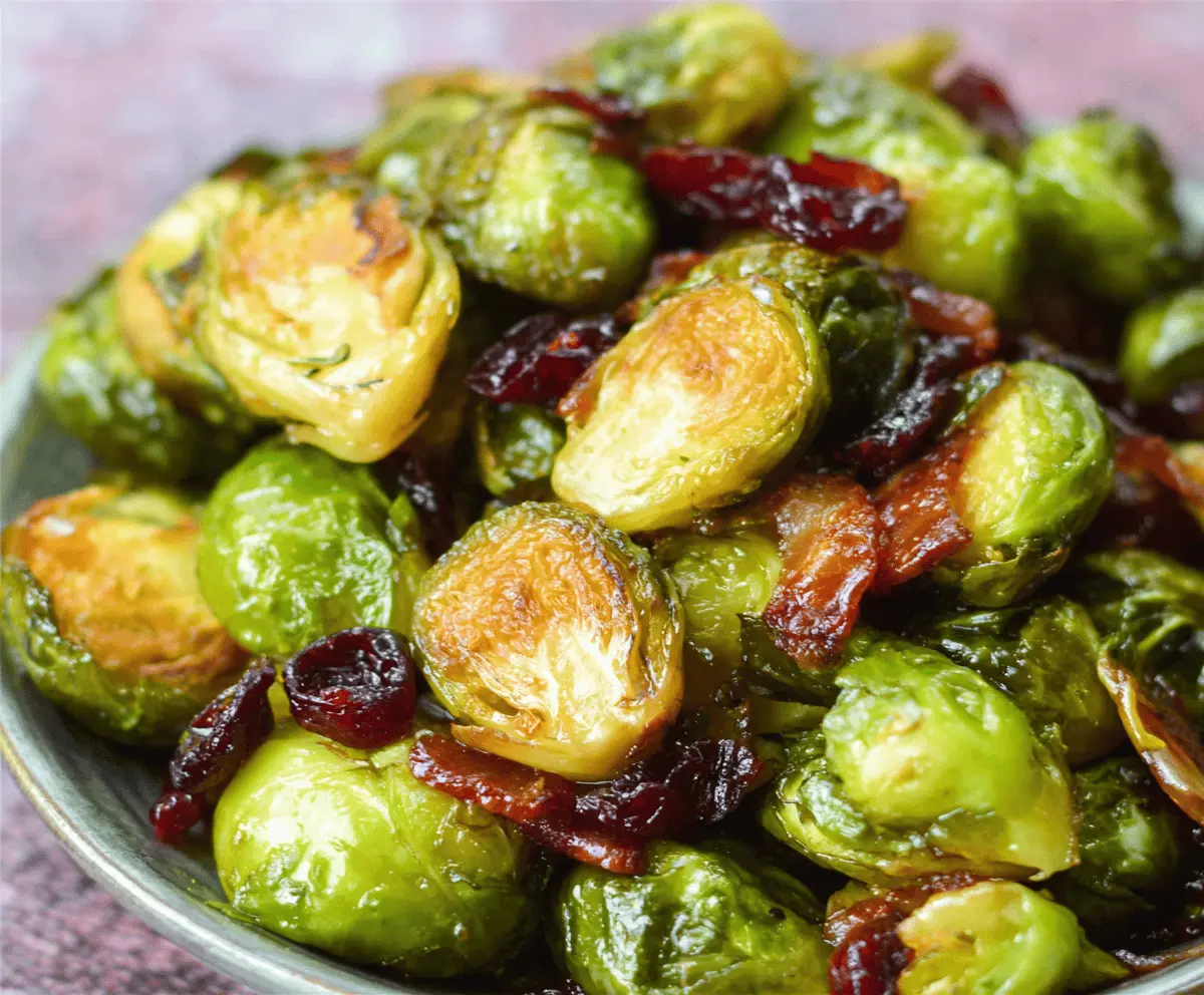 Delicious orange maple glazed Brussels sprouts garnished with fresh cranberries, perfect for a festive side dish.