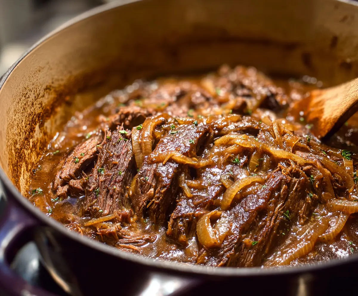 Delicious French onion pot roast served in a rustic bowl with caramelized onions and tender meat.