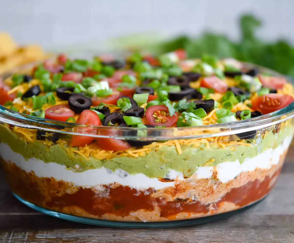 Delicious Ultimate 7 Layer Dip with various toppings and vibrant colors perfect for parties