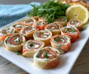Easy smoked salmon pinwheels on a platter, perfect party appetizers with creamy filling and fresh herbs.