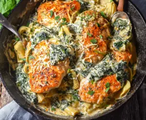 Creamy spinach and artichoke chicken skillet for a low-carb dinner, showcasing tender chicken breasts topped with spinach and artichoke mixture.